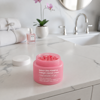 Pot ouvert de Crème Collagène PDRN Pink Lumeya Paris avec capsules de collagène, dans une salle de bain en marbre